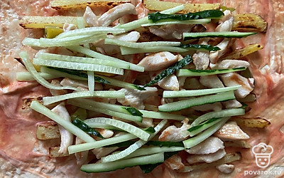 Огурчик режем соломкой и выкладываем на курицу.