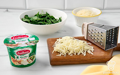 Крупно нарежьте шпинат. Натрите моцареллу и пармезан. Смешайте сыры с козьей рикоттой и шпинатом. Разбейте в миску яйца и перемешайте.