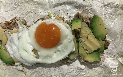 Выложить жареное яйцо и сыр по желанию. Свернуть и обжарить на сухой сковороде, с двух сторон по 5 минут.