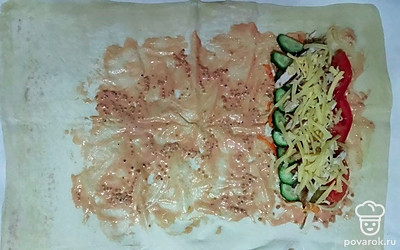 Приступайте к сборке шаурмы. Лаваш первым делом смажьте соусом из смеси кетчупа, майонеза и горчицы. Далее по очереди выложите все измельченные ингредиенты, начиная с капусты и моркови. За ними следуют огурцы и помидоры, потом мясо и в конце сыр. Сверните по форме рулета и подогните края. Отправьте заготовки в электрогриль на 10 минут.