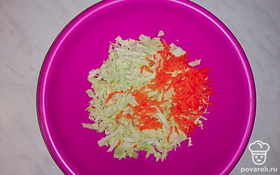 Морковь чистим, моем, натираем и отправляем к капусте. Добавляем щепотку чёрного перца. 
