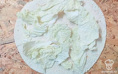 Листья пекинской капусты порвать на кусочки среднего размера, выложить на лепёшку.