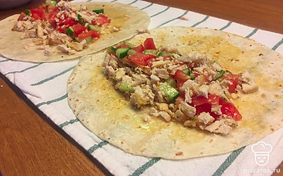 Собираем нашу шаверму: берем тортилью, смазываем ее оливковым маслом. Выкладываем мелко порезанные ингредиенты: куриную грудку, помидор и огурец. Добавляем острую зажарку.