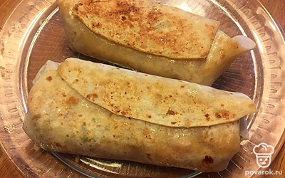 Обжариваем тортилью на сковороде, где жарилась острая зажарка. По минуте с каждой стороны.