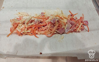 Начните готовить непосредственно шаурму. Выложите лист лаваша и в распределите по нему полученную массу. Заверните шаурму.