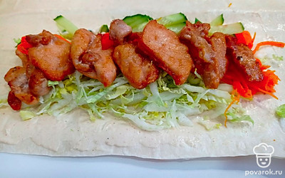 Для соуса смешиваем половину чайной ложки мёда с измельчённым чесноком, добавляем лимонный сок, черный молотый перец, соль, майонез и сметану. Хорошо вымешиваем соус и смазываем им лаваш. Сначала выкладываем "овощную подушку", затем мясо и сверху немного соуса.