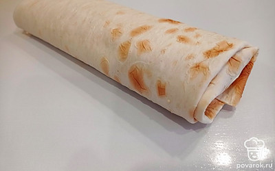 Заворачиваем шаурму, делая тугой рулет. Но сильно не передавливаем, иначе лаваш может порваться. Подсушиваем шаурму на сковороде с двух сторон.
