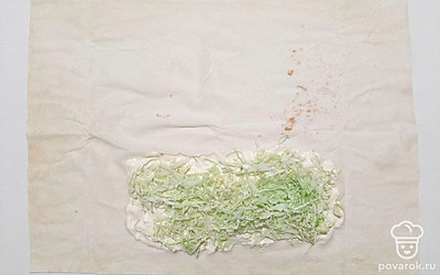 Нашинкуйте капусту. Затем смажьте 1/3 лаваша соусом, отступая от краев, и положите сверху нашинкованную капусту.