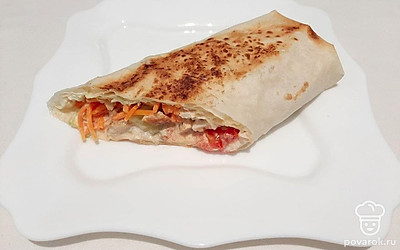 Разрежьте шаурму пополам и выложите на тарелку. При желании украсьте зеленью.