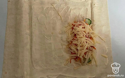 Нарежьте кальмар дольками и положите его на лаваш. Так же добавьте сыр и морковь по-корейски. Заверните лаваш в виде шаурмы. Отправьте в духовку, разогретую до 220 ℃ на 15 минут. Затем выключите духовку и дайте дойти еще 5 минут.