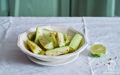  Разрежьте кабачок пополам поперек на две равные части. Каждую половинку кабачка разрежьте на четвертинки.