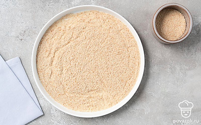 Насыпьте на плоскую керамическую тарелку панировочные сухари. Разровняйте их, чтобы они покрывали тарелку тонким слоем.