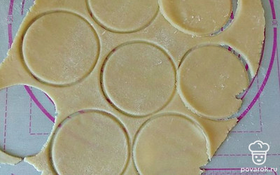 На расскатанном тесте вырежьте небольшие круги соразмерно формочкам, в которых будут выпекаться тарталетки.
