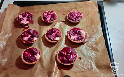 На противень положите коврик для запекания, выложите тарталетки на коврик, творожный крем в тарталетки, сверху в тарталетки положите вишню.