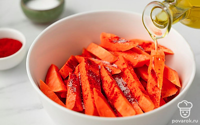 Переложите нарезанный батат в миску. Добавьте масло, соль и паприку. Тщательно перемешайте ингредиенты руками.