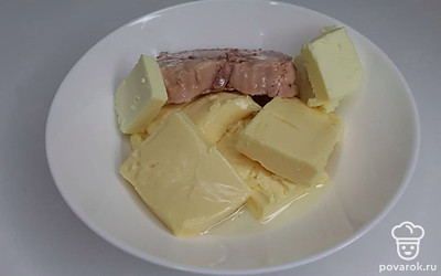 В миску выложите печень трески, плавленый сыр и сливочное масло; тщательно перемешайте до однородной массы. Лимон разрежьте пополам, выдавите сок из половины и добавьте в полученную смесь.