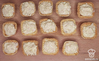 Подготовленный болгарский перец промойте и порежьте ломтиками, оливки порежьте пополам. Наполните тарталетки готовой начинкой и сверху украсьте оливками и болгарским перцем.