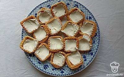 Наполните тарталетки творожным сыром почти до самого верхнего края. Следите, чтобы осталось место для рыбы.