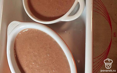 Вылейте массу в жаропрочную форму и поместите их в большой противень. Залейте горячей водой для водянной бани. Поставьте в духовку при 120 градусах на 25 минут, предварительно накрыв смоченной пергаментной бумагой. 