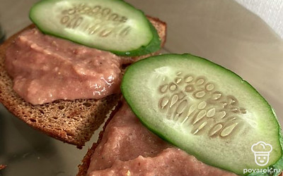 Подать паштет, намазав его на гренку, сверху украсить ломтиком тонко нарезанного огурчика.