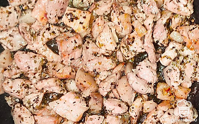 Разогрейте сковороду на среднем огне. Влейте масло. Свинину порежьте крупными кубиками и выложите на сковороду. Обжарьте свинину о золотистой корочки и добавьте специи и соль.