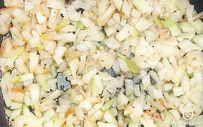 Поставьте сковороду на газ и разогрейте. Очистите лук от шелухи и порежьте мелким кубиком. Выложите лук на сковороду и обжарьте до золотистого цвета.