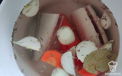 Отрежьте хвост и голову у рыбы. Выложите ее в кастрюлю и залейте водой. Морковь порежьте на крупные куски. Лук очистите и порежьте на 4 части, половинку лука оставьте, выложите лук в кастрюлю. Добавьте тимьян, лавровый лист, соль, перец и вино. Вскипятите содержимое кастрюли и выключите газ. Дайте настояться рыбе под крышкой 15 минут.