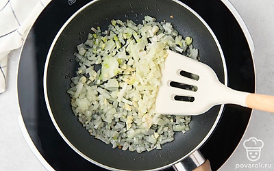 Мелко покрошите лук и чеснок. Разогрейте на сковороде растительное масло. Обжарьте лук с одним зубчиком чеснока на среднем огне в течение 3 минут. После этого остудите зажарку.