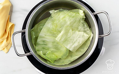 Налейте в кастрюлю 1,5-2 л воды. Вскипятите ее на сильном огне, всыпьте половину приготовленной соли. Опустите в кастрюлю капустные листья и проварите в течение 6-7 минут. Выложите капустные листья на тарелку и дайте им остыть.