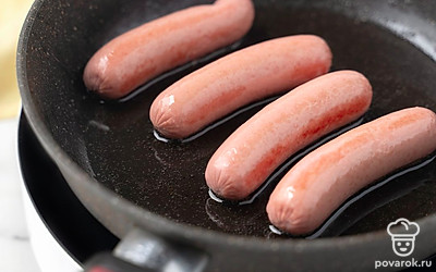 Разогрейте на сильном огне сковороду с 0,5 ст.л. растительного масла. Обжарьте на ней сосиски со всех сторон до румяной корочки. Снимите сковороду с огня. 