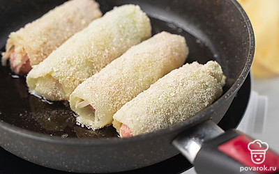 Налейте в сковороду оставшееся растительное масло, снова разогрейте на сильном огне. Жарьте сосиски в капусте, периодически поворачивая сырой стороной вниз, в течение 4-5 минут до хрустящей золотистой корочки.