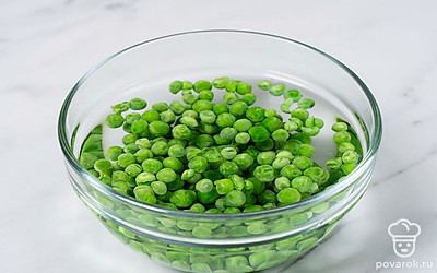 Выложите зеленый горошек в глубокую миску. Залейте его кипятком на 3-4 минуты.