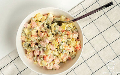 Соберите салат. Измельченные продукты соедините в салатнике, добавьте зеленый горошек, заправьте майонезом, посолите и перемешайте.