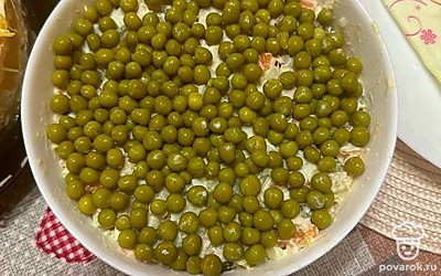 Украсьте салат консервированным горошком. Подавайте на стол.