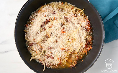 Налейте в сковороду 0,5 стакана горячей воды, уменьшите огонь до среднего. Потушите содержимое сковороды около 10 минут, пока рис не впитает воду.