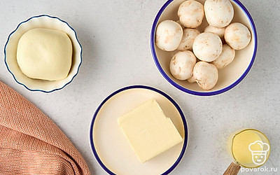 Помойте шампиньоны, протрите их насухо салфеткой. Отмерьте нужное количество всех ингредиентов. Уберите масло в морозилку на 10 минут. Застелите противень пергаментом.