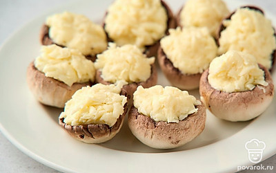 Нафаршируйте сырно-масляной смесью каждый гриб. Утрамбуйте начинку поплотнее и сделайте небольшую горку сверху.