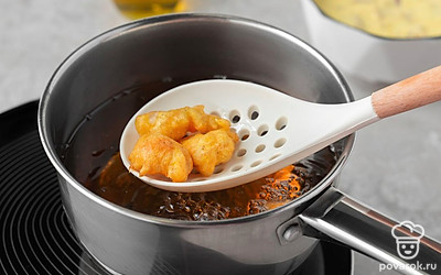 Налейте в сотейник масло, разогрейте его на среднем огне. Опускайте индейку во фритюр небольшими порциями. Жарьте их, помешивая шумовкой, по 1 минуте до золотистой корочки.