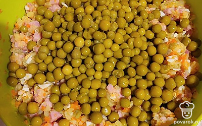 Открываем консервированный горошек и добавляем ко всем нарезанным ингредиентам, перемешиваем.