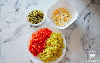 Морковь и картофель, не очищая, отварите в течение 25-30 минут до готовности. Яйца, также, не очищая, отварите вкрутую. Соленые огурцы нарежьте мелкими кубиками. Остывшие яйца очистите от скорлупы и нарежьте мелкими кубиками. Остывшие отваренные овощи очистите от кожуры и нарежьте кубиками среднего размера.