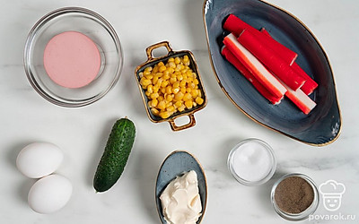 Помойте и обсушите яйца и огурец. Снимите с крабовых палочек и колбасы оболочку. Приготовьте кастрюлю, дуршлаг, разделочную доску и салатник.