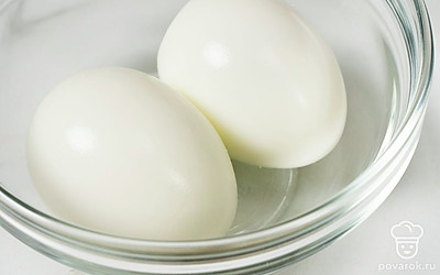 Положите яйца в кастрюлю, налейте к ним воду. Поставьте на плиту, доведите воду до кипения на сильном огне. Убавьте огонь до среднего, отварите яйца в течение 7-8 минут. Остудите яйца в холодной воде и очистите их от скорлупы.