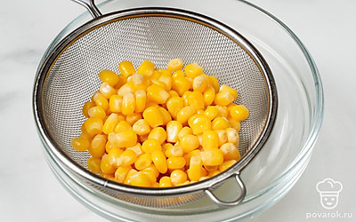Выложите консервированную кукурузу в дуршлаг, дайте стечь жидкости.