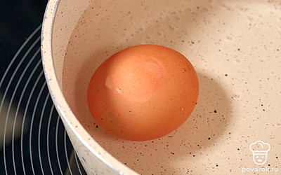 Опустите яйцо в сотейник с водой. Поставьте его на огонь и оставьте до кипения. После этого убавьте нагрев и варите яйцо в течение 7-8 минут.