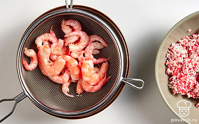 Отварите креветки. Поставьте кастрюлю с водой на плиту и вскипятите. Затем добавьте 1 ст. л. морской соли. Если креветки очищенные, количество соли уменьшите в два раза. Добавьте лавровый лист, горошины перца и гвоздику. Опустите креветки в кастрюлю, варите с момента повторного закипания приблизительно 5-7 минут. Затем выложите креветки на дуршлаг, остудите и очистите.