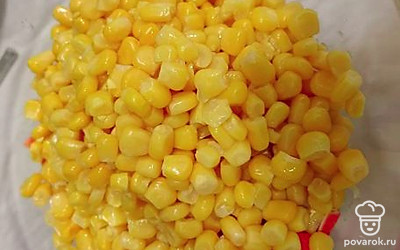 Консервированную кукурузу откинуть на дуршлаг и добавить в салатник.