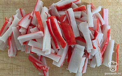 Нарезать крабовые палочки.