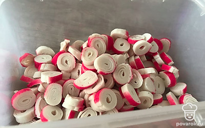 Крабовые палочки нарезаем кружочками и выкладываем в миску.