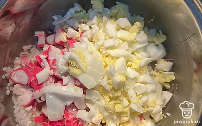 Отварите яйца и нашинкуйте. Добавьте к крабовым палочкам и рису.