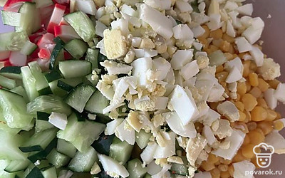Огурец измельчите кубиками, добавьте кукурузу и перемешайте.